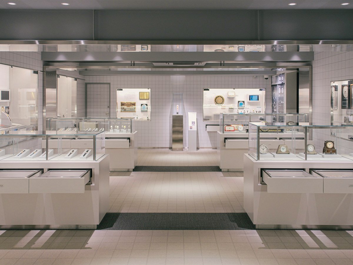 Premium retail interior with illuminated jewellery display cases and warm stone finishes