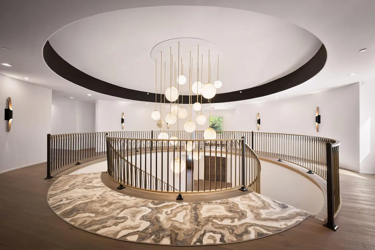 Modern architectural interior design featuring circular staircase and chandelier by Artistic Dimension
